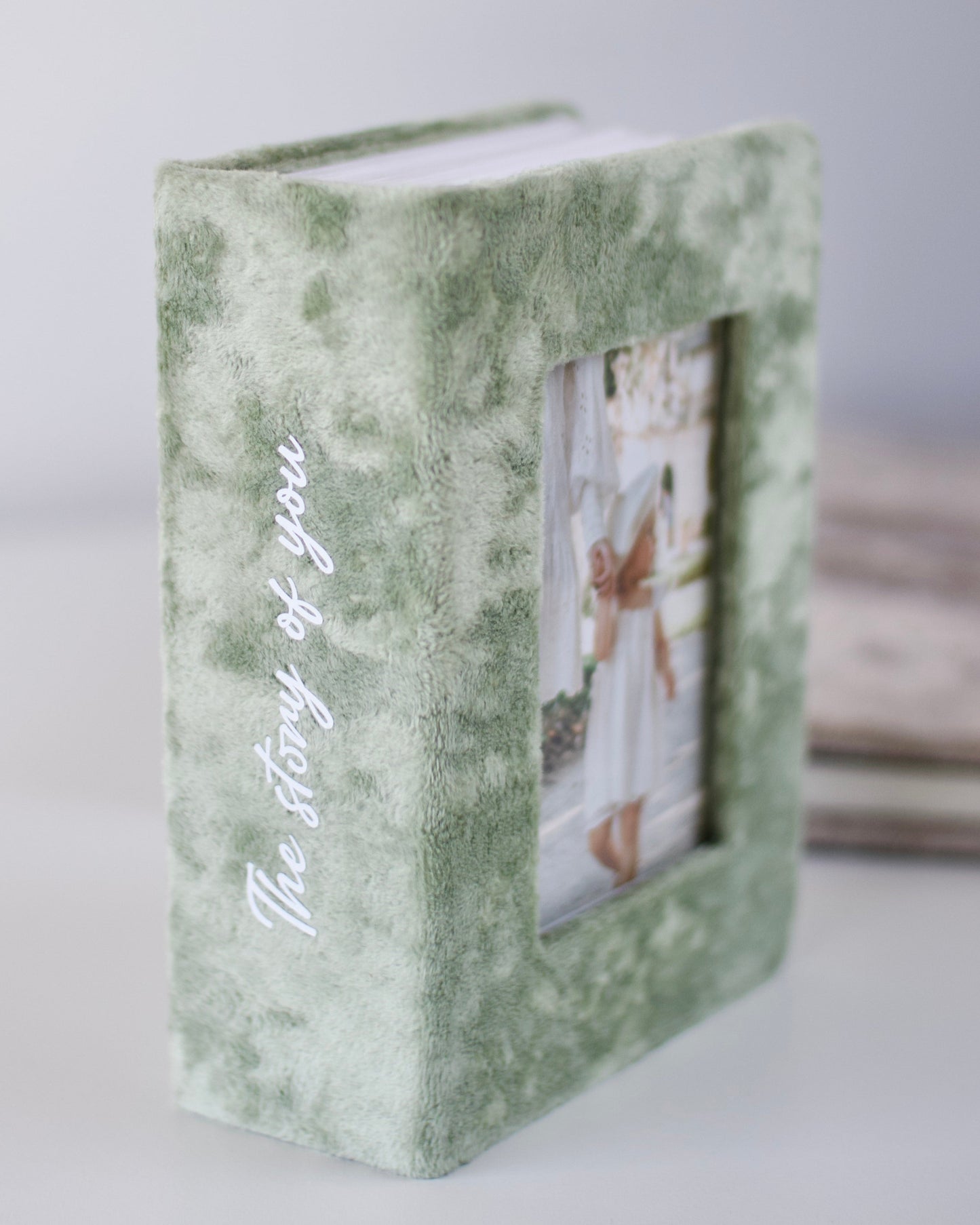 Green photo album with 'The Story of You' text on a white background