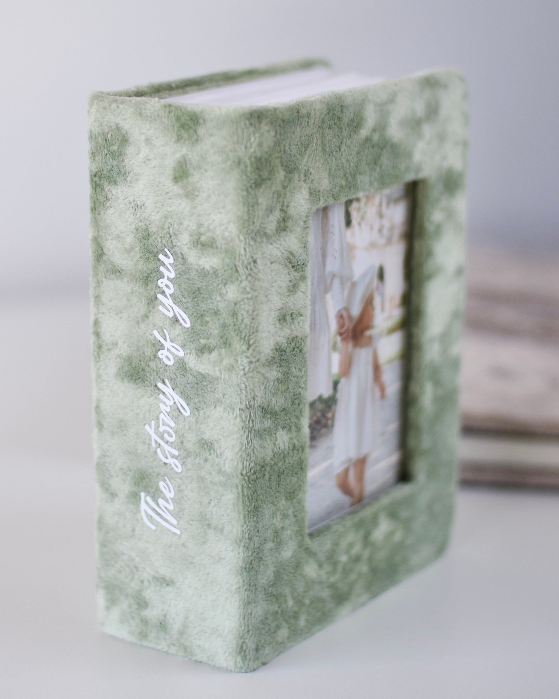 Green photo album with 'The Story of You' text on a white background