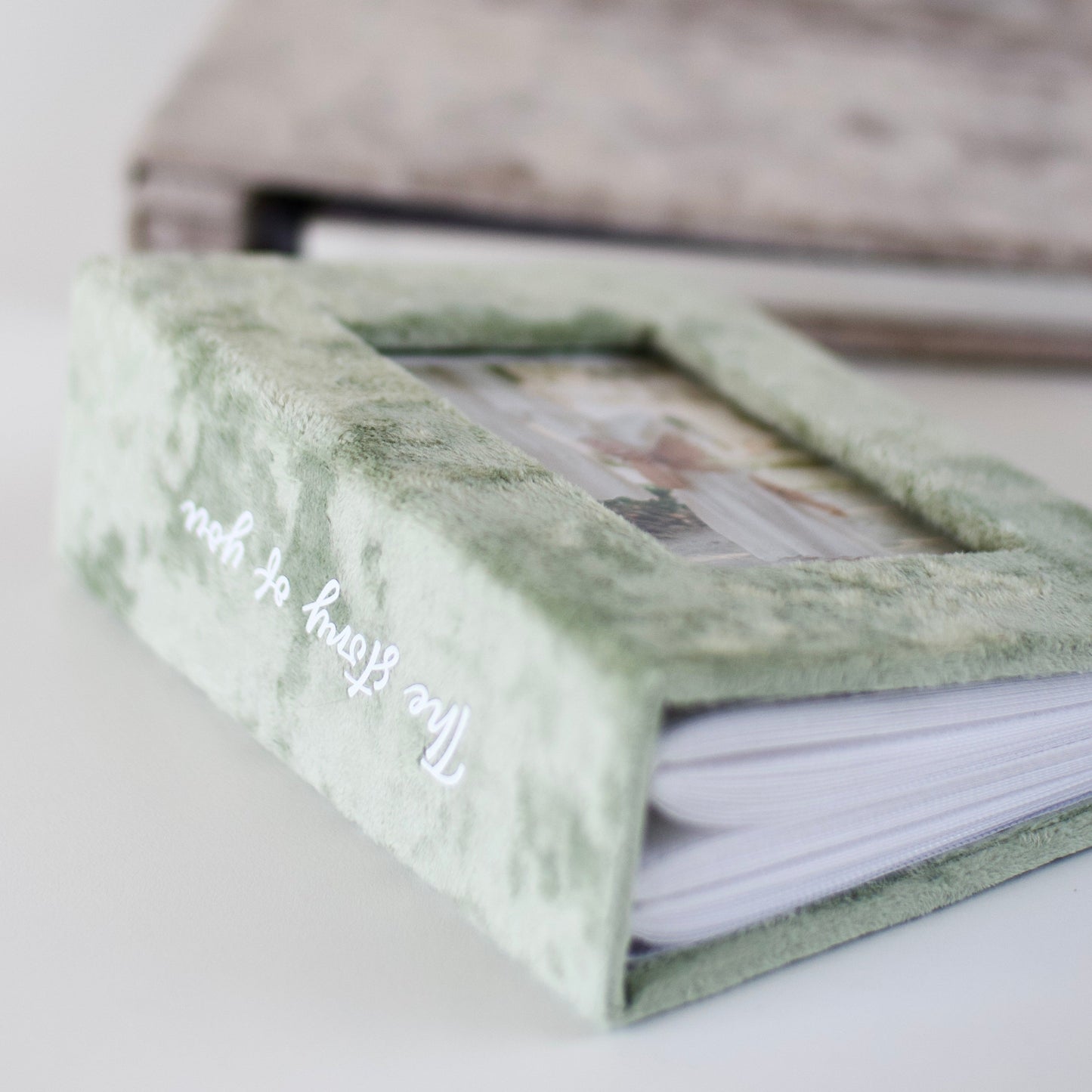 Green photo album with marble texture on a white surface