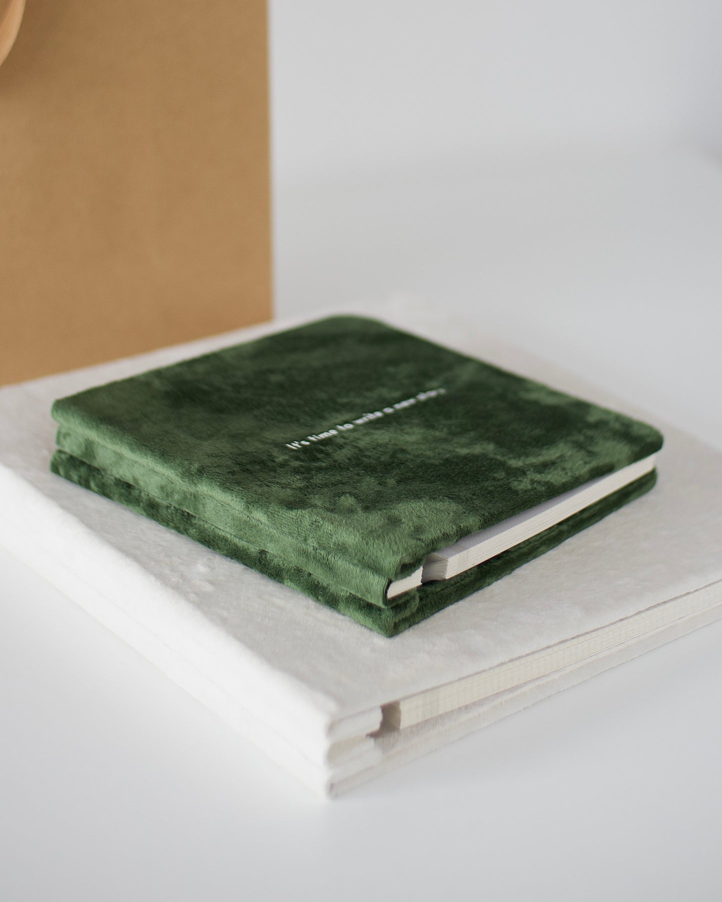 Green marble notebook on a white surface with a blurred background