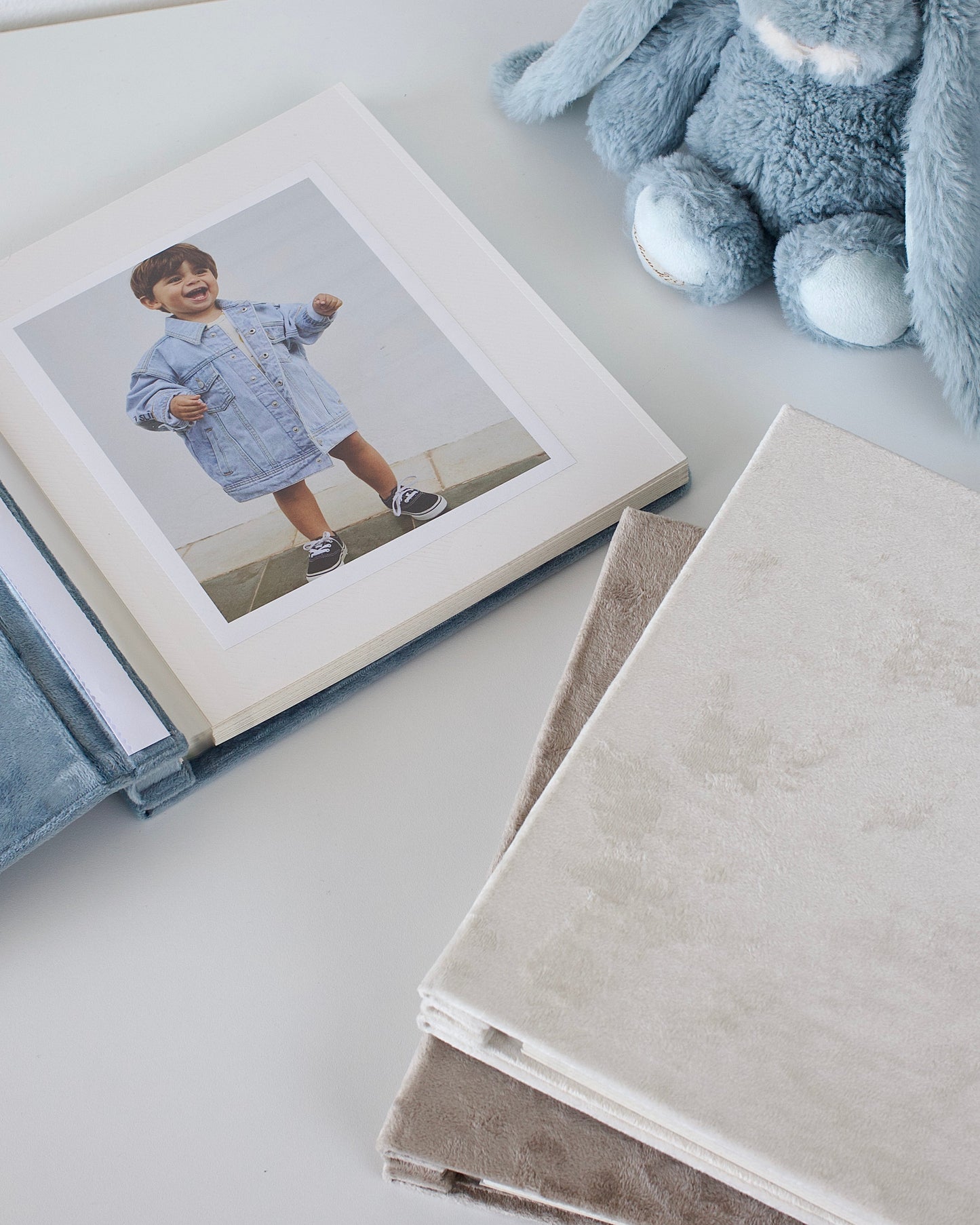 Album with a photo of a child and a plush toy on a light surface